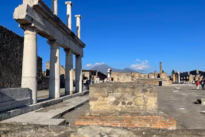 Discover Pompeii's iconic ruins and columns with views of Mount Vesuvius on a small group tour from Positano.