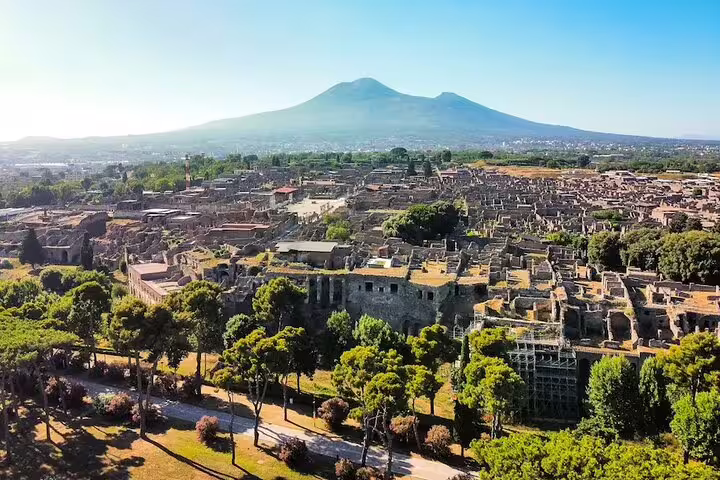 Panoramic view of Pompeii ruins with Mount Vesuvius in the background, a highlight of guided small group tours from Naples