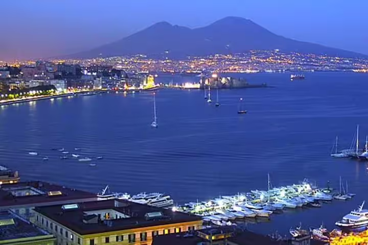 Twilight view of Naples bay and Mt Vesuvius with yachts in the harbor, starting point for Pompeii and winery day tours
