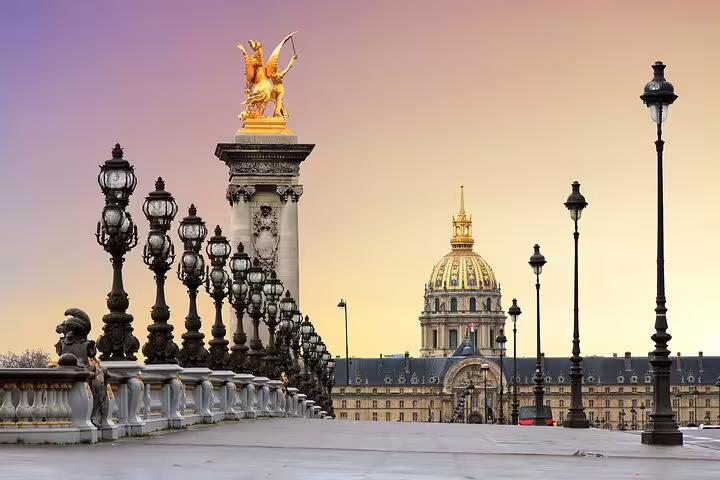 Golden hour view of the ornate Pont Alexandre III bridge leading to Les Invalides, perfect for a Paris private tour highlight.