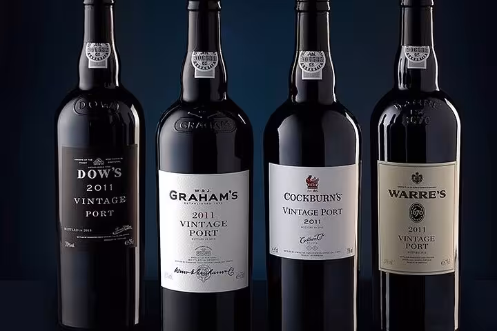 A selection of four 2011 vintage Port wine bottles, ideal for enhancing a Brazilian BBQ dinner in Rio.