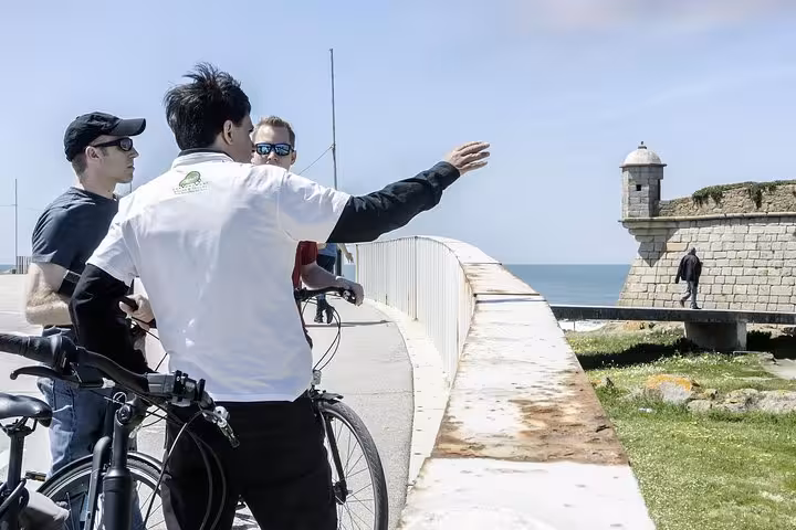 Cyclists enjoy scenic views and historical sites on a guided Porto bike tour along the coastal fortifications.