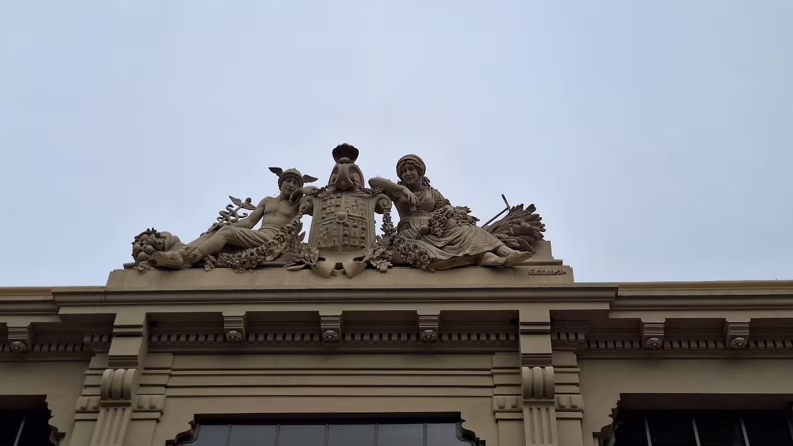 Ornate architectural sculpture atop Porto's historic building, showcasing detailed craftsmanship on a private afternoon tour.