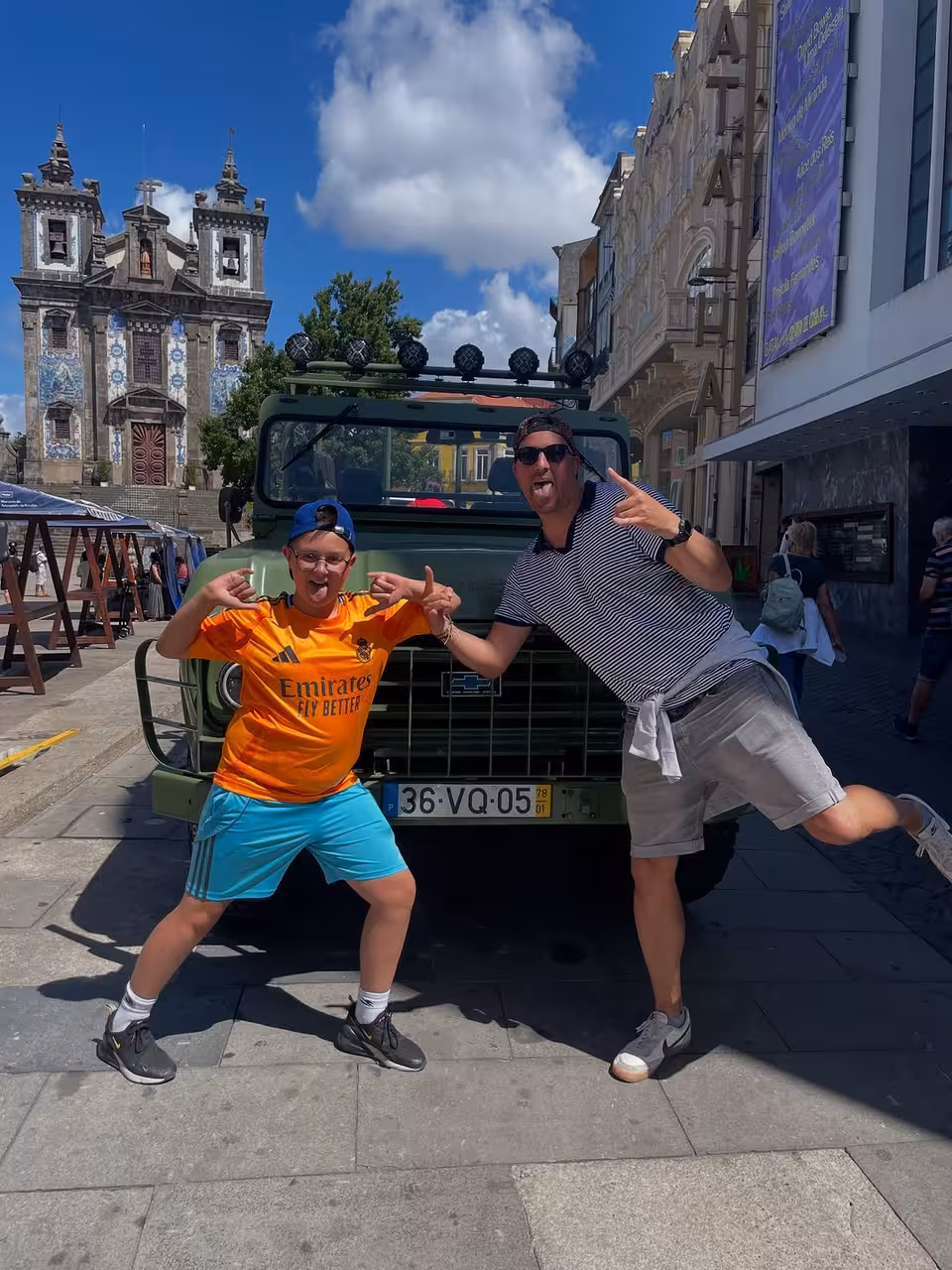 Travelers pose by 4x4 jeep at Igreja do Carmo, Porto historical sites tour with Douro viewpoints