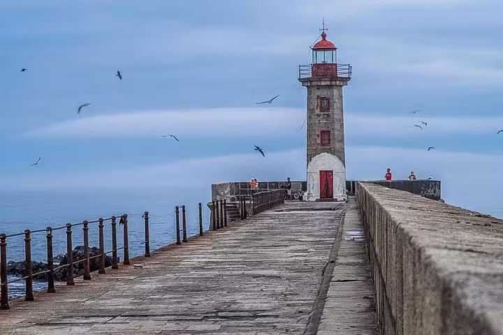 Scenic view of Porto lighthouse and pier, perfect for a coastal stop on the 3-hour small-group bike tour.