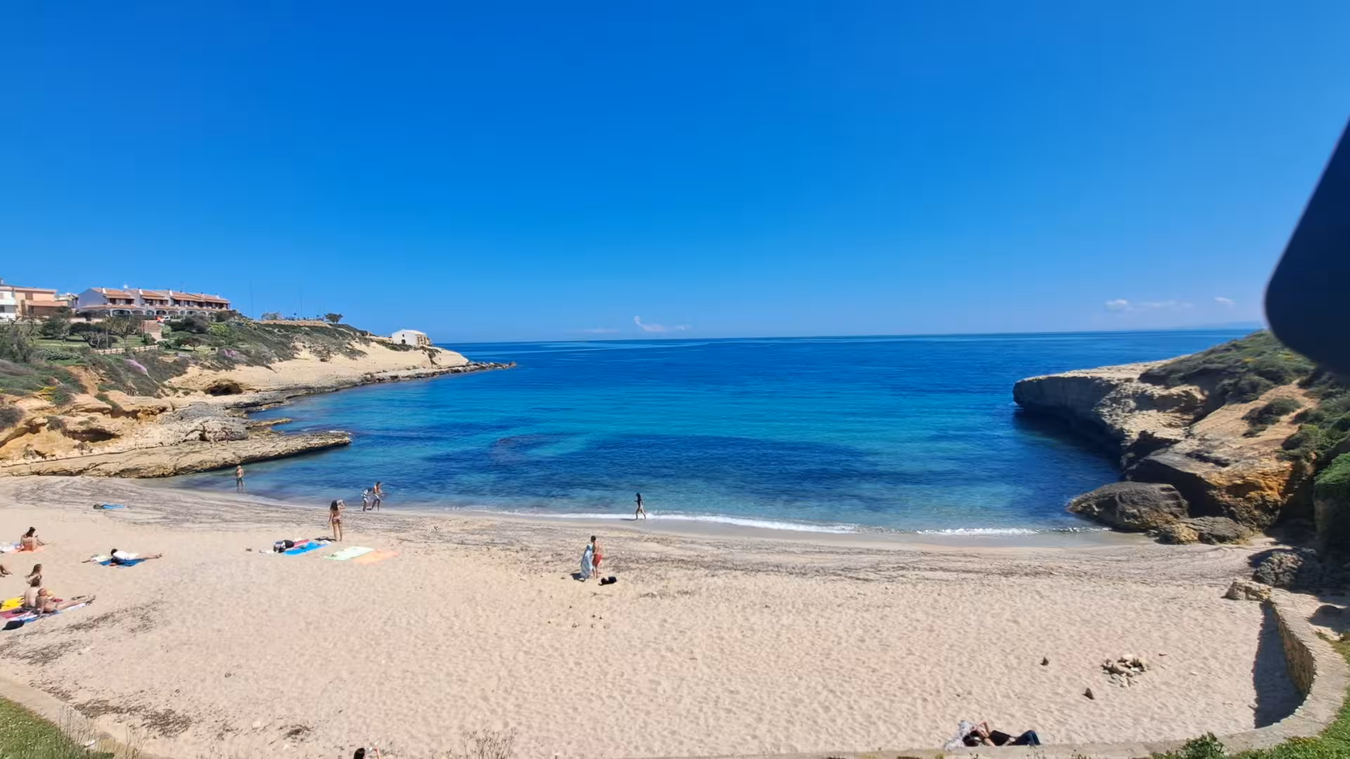 Scenic Porto Torres beach with clear blue waters, perfect for a relaxing dive baptism experience.