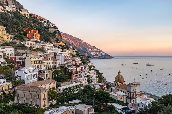 Scenic view of Positano's colorful cliffside houses overlooking the Amalfi Coast at sunset, perfect for a full-day tour.