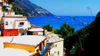Colorful cliffside houses overlooking the bright blue sea in Positano on a Naples and Amalfi Coast full day tour from Rome