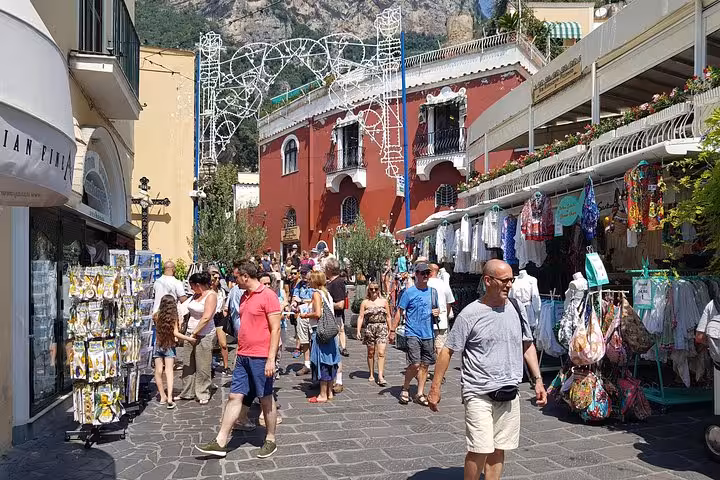 Crowded Positano shopping street on a Rome to Amalfi Coast day trip, browsing boutiques and souvenirs