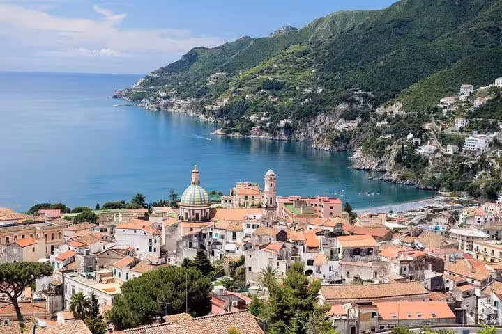 Panoramic view of Positano's terracotta rooftops, lush hillsides, and sparkling coastline along the Amalfi Coast.