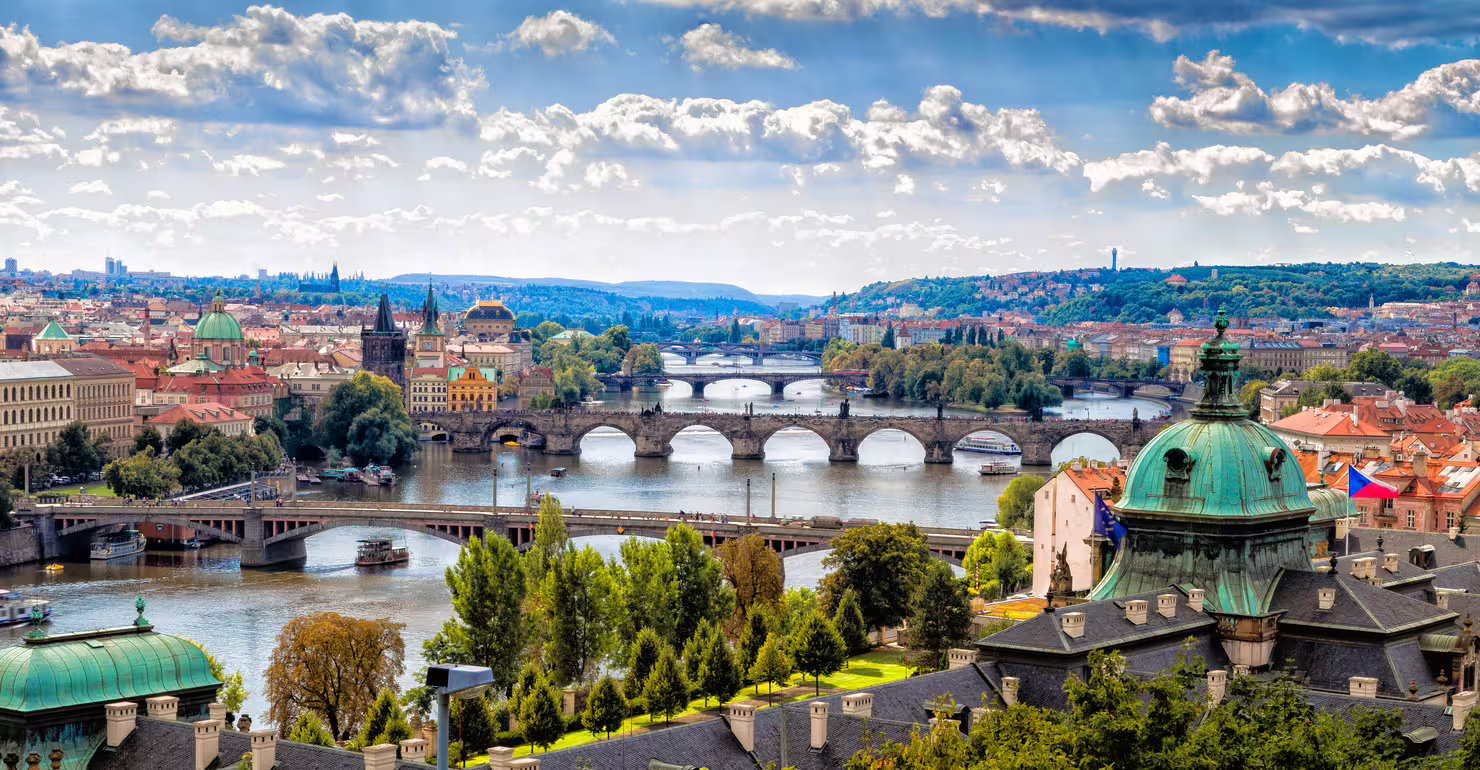 Panoramic Prague skyline with Vltava bridges and green domes, ideal for Prague 1-day audio walking tour