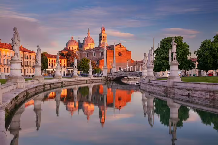 Prato della Valle canal at sunset in Padua with statues, bridge and domes, visited on a private top sights walking tour