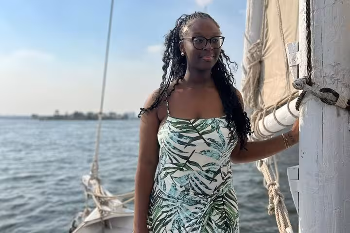 Woman on a traditional Nile sailboat in Cairo, enjoying a private birthday cruise experience with lunch or dinner