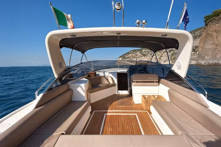 Spacious deck of a private boat with comfortable seating, cruising along the scenic shores of Positano.
