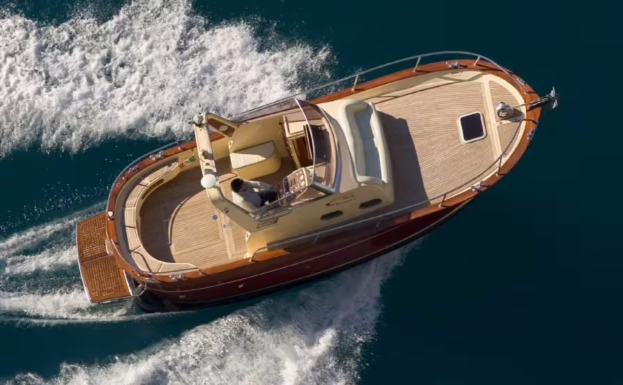 Elegant private boat cruising between Capri and Amalfi, showcasing spacious teak deck and luxurious transfer experience
