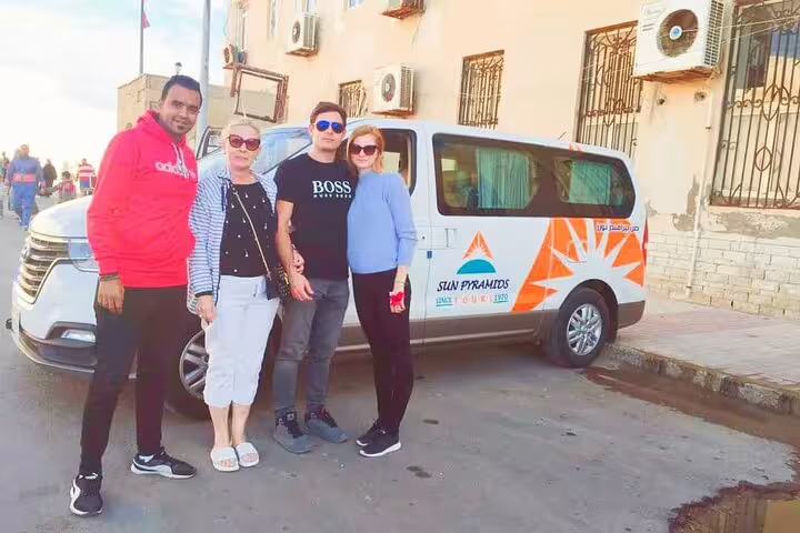 Travelers pose beside private Cairo airport transfer van, reliable hotel pickup and drop-off service