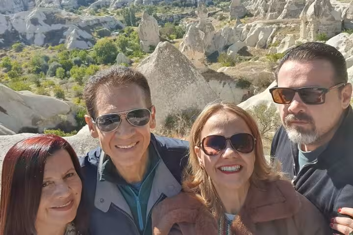 Group selfie overlooking Cappadocia valleys and fairy chimneys on a private tour with English guide and luxury vehicle
