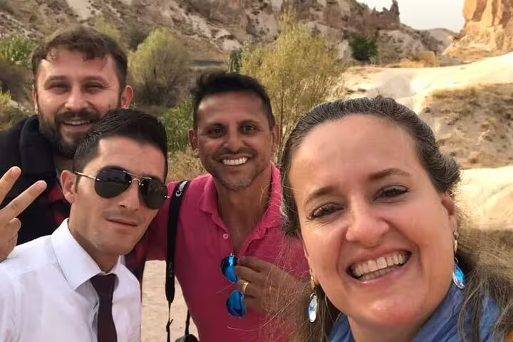 Smiling group of friends exploring Cappadocia's stunning landscape on a private tour from HOTELS and ASR-NAV Airport.