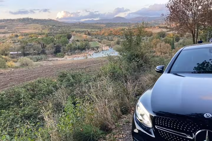 Private car parked with a panoramic view of the Tuscan countryside en route to Terme di Saturnia.