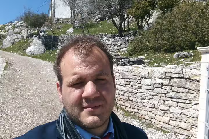 Private Delphi and Olympia 2-day tour guide at Greek stone path near historic ruins and olive trees