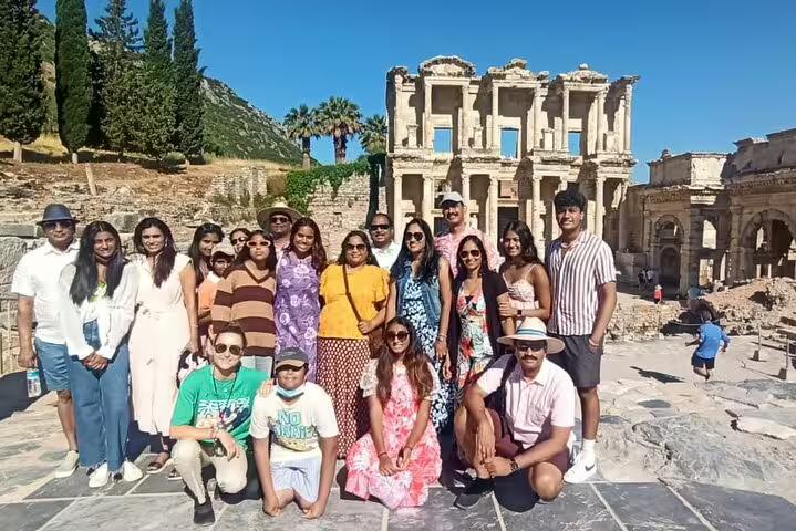 Group of tourists enjoying a sunny day at the Celsus Library during a private Ephesus tour with entry fees and lunch.