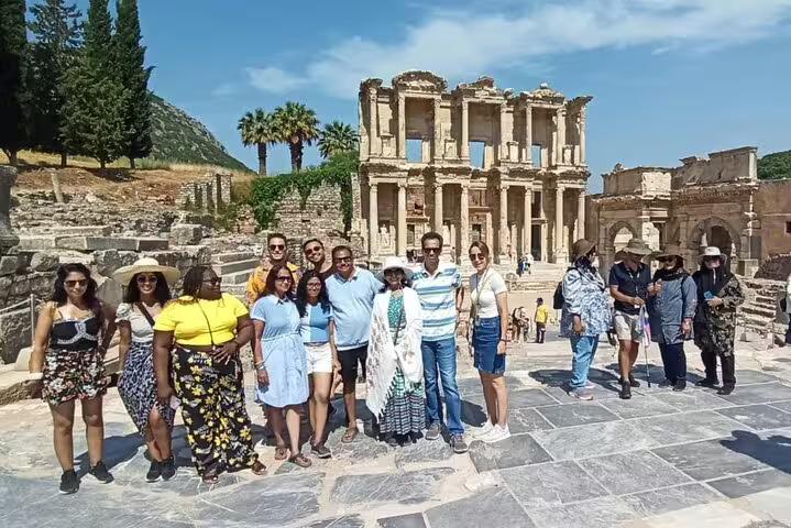 Smiling travelers pose in front of the iconic Celsus Library on a private Ephesus excursion, including entry and lunch.
