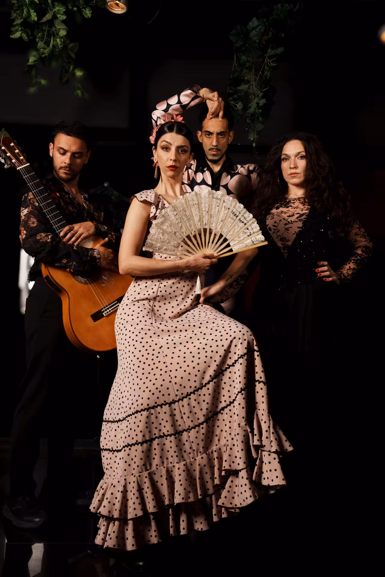 Elegant flamenco ensemble with dancers and guitarist showcasing traditional artistry.