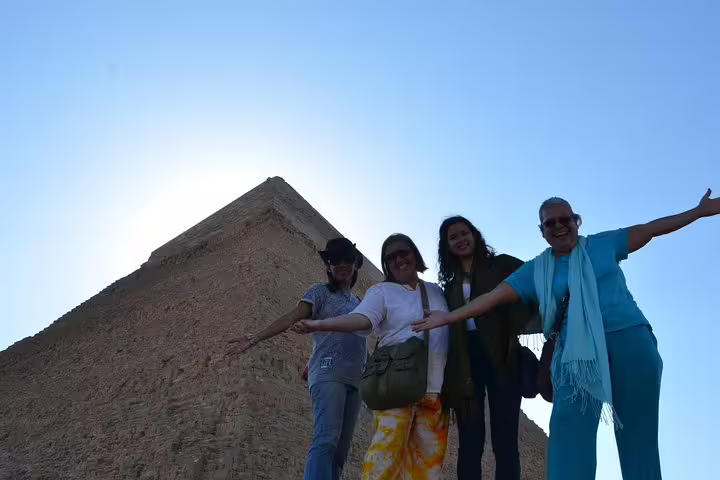 Private Giza Pyramids tour group photo with travelers posing beside pyramid during 3-hour Egypt visit