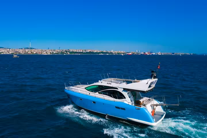 Private Istanbul Bosphorus yacht cruise with luxury motor yacht sailing on blue sea near skyline