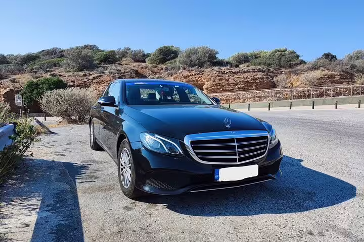 Private Lefkada to Athens transfer sedan parked roadside, comfortable door-to-door chauffeur transport in Greece