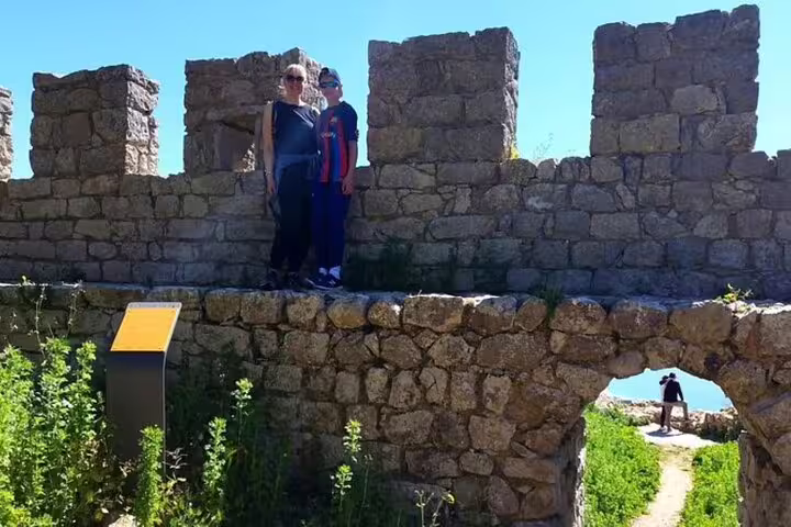 Tourists exploring ancient stone ruins on a sunny day during a private 4X4 Jeep and beach picnic tour in Arrábida, near Sesimbra-Lisbon.