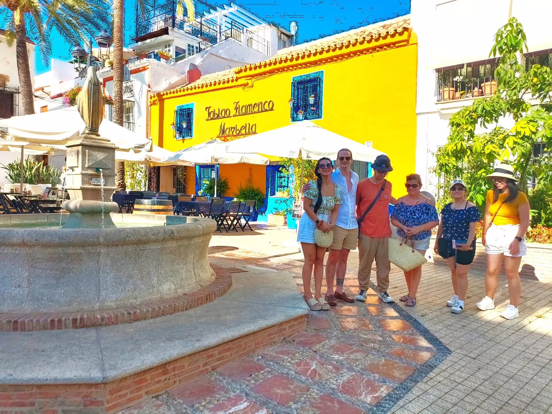 Private Marbella tour from Malaga with group at Plaza de los Naranjos fountain and colorful Old Town facade