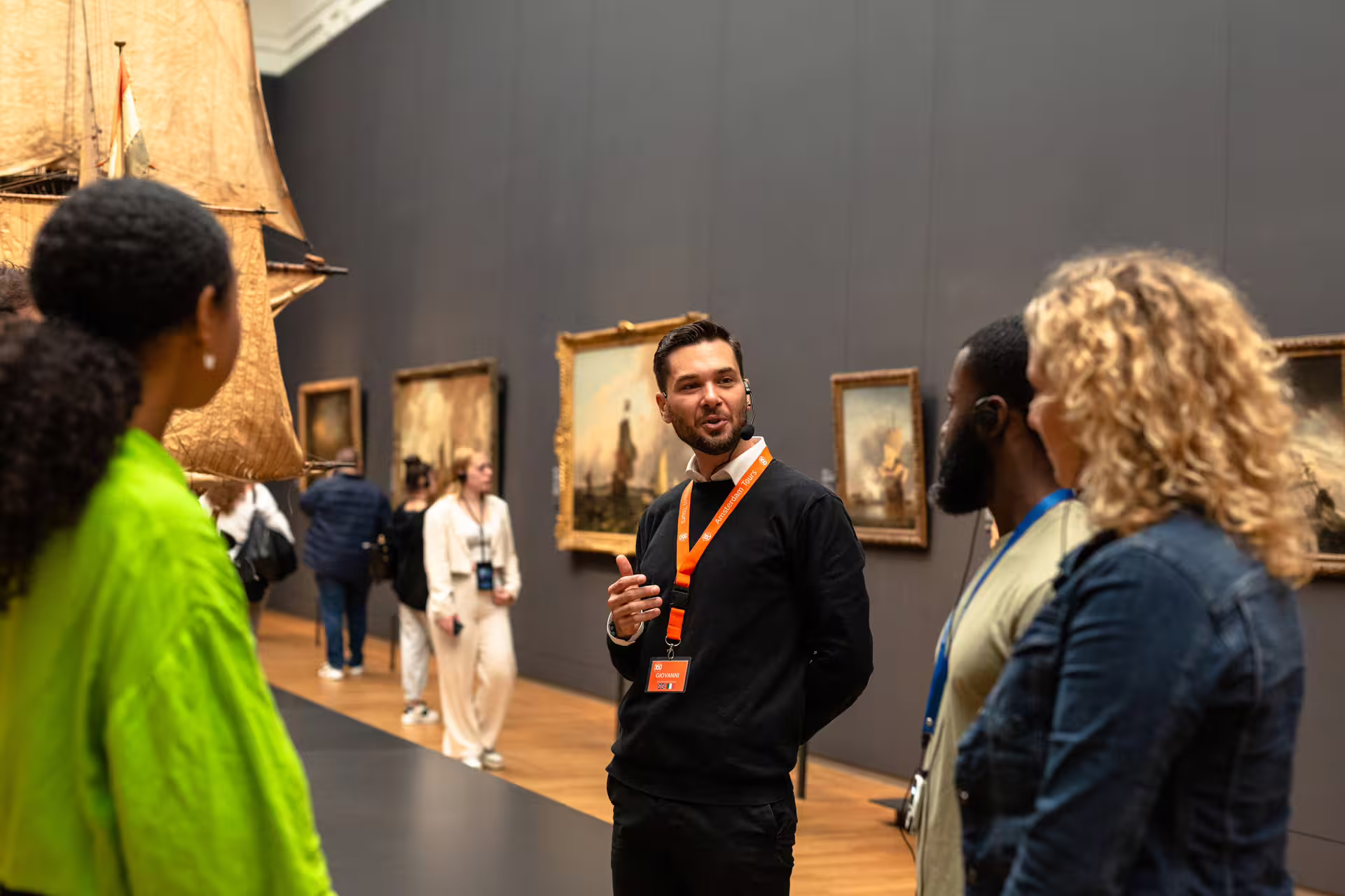 Tour guide engaging visitors in a private Rijksmuseum tour, showcasing iconic artworks and historical exhibits in Amsterdam.