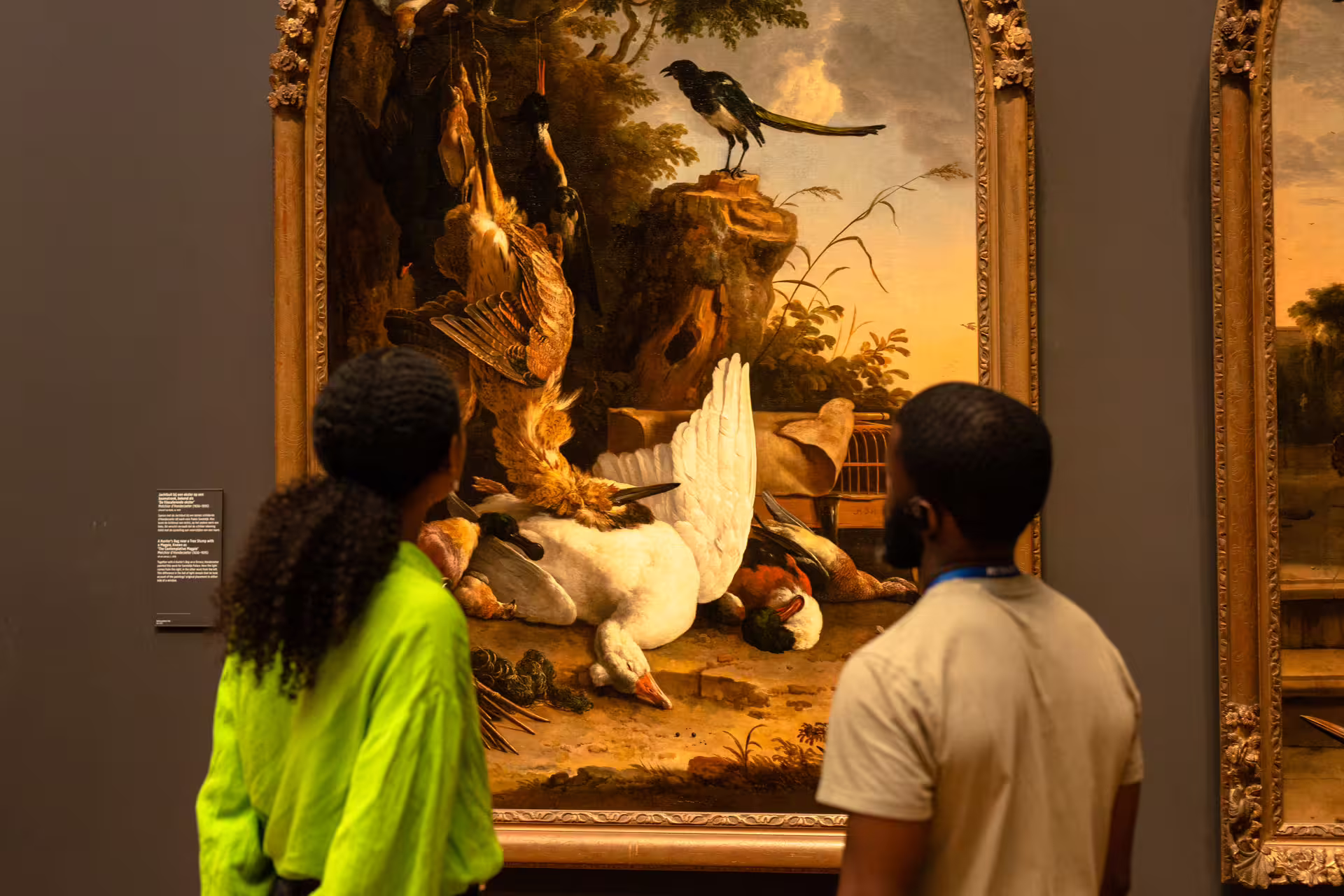 Visitors admire a detailed still life painting during a private guided tour at the Rijksmuseum, Amsterdam's art treasure.