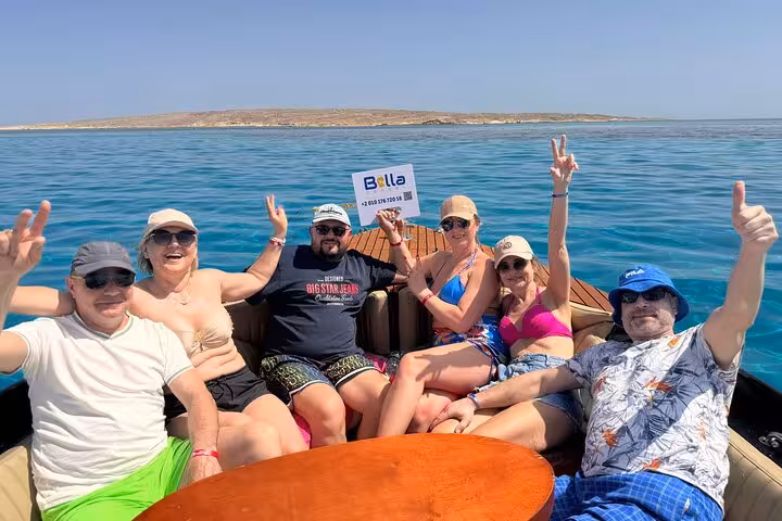 Happy group relaxing on private speedboat to Orange Bay Island from Hurghada, Red Sea snorkeling trip