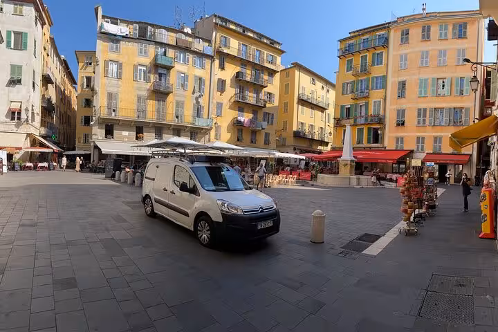 Private tour van in Nice Old Town square with colorful facades and cafés on a day trip to Eze and Monaco