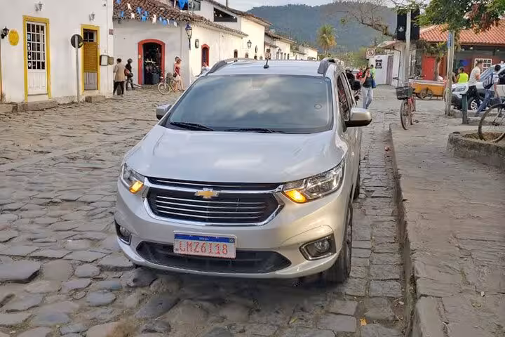 Silver Chevrolet car on a cobblestone street, used for private transfers from Guarulhos Airport to São Paulo hotels.