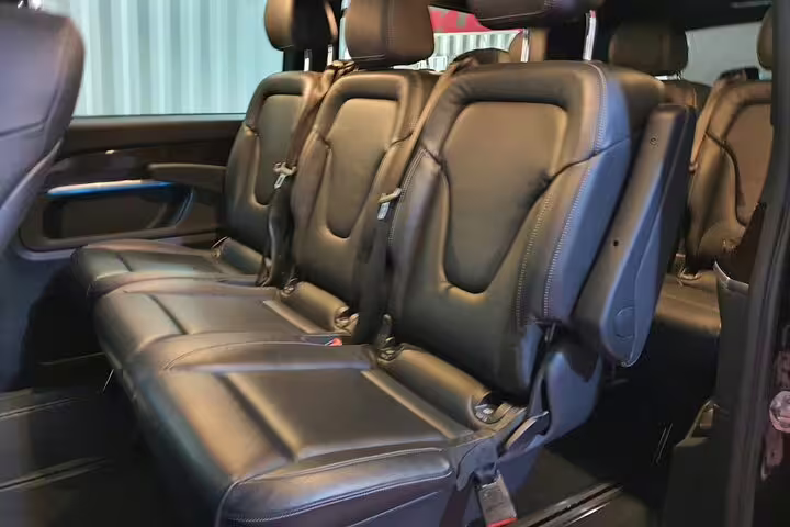 Spacious black leather van interior for private transfer from Madrid Barajas Airport to central Madrid hotel
