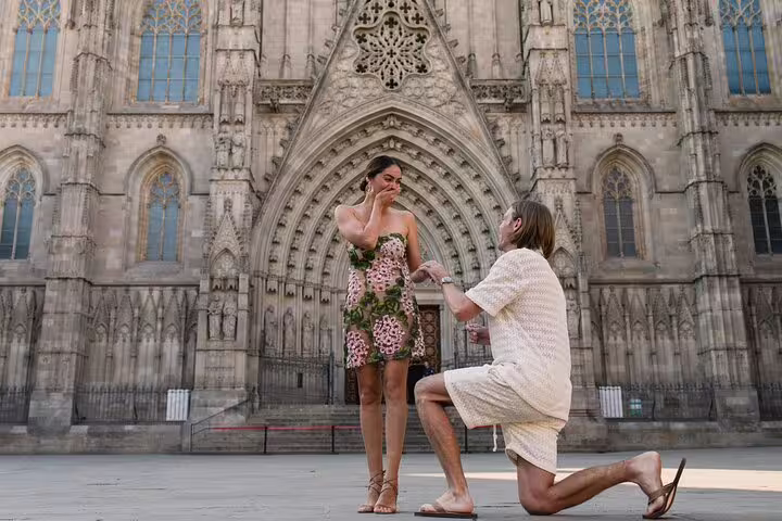 Surprise proposal photo shoot at Barcelona Cathedral, groom kneeling with ring as bride reacts emotionally