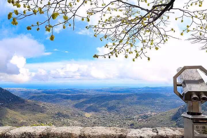 Scenic panoramic view of the Provencal countryside from a hilltop, featuring a telescope for enhanced sightseeing.