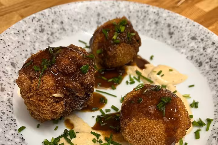 Crispy Provençal croquettes plated after a Marseille cooking class with a local chef, finished with herb sauce
