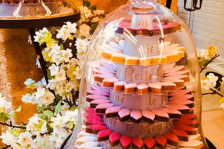 Colorful Provençal macarons under a glass dome, sweet stop on Aix-en-Provence Cézanne wine tour