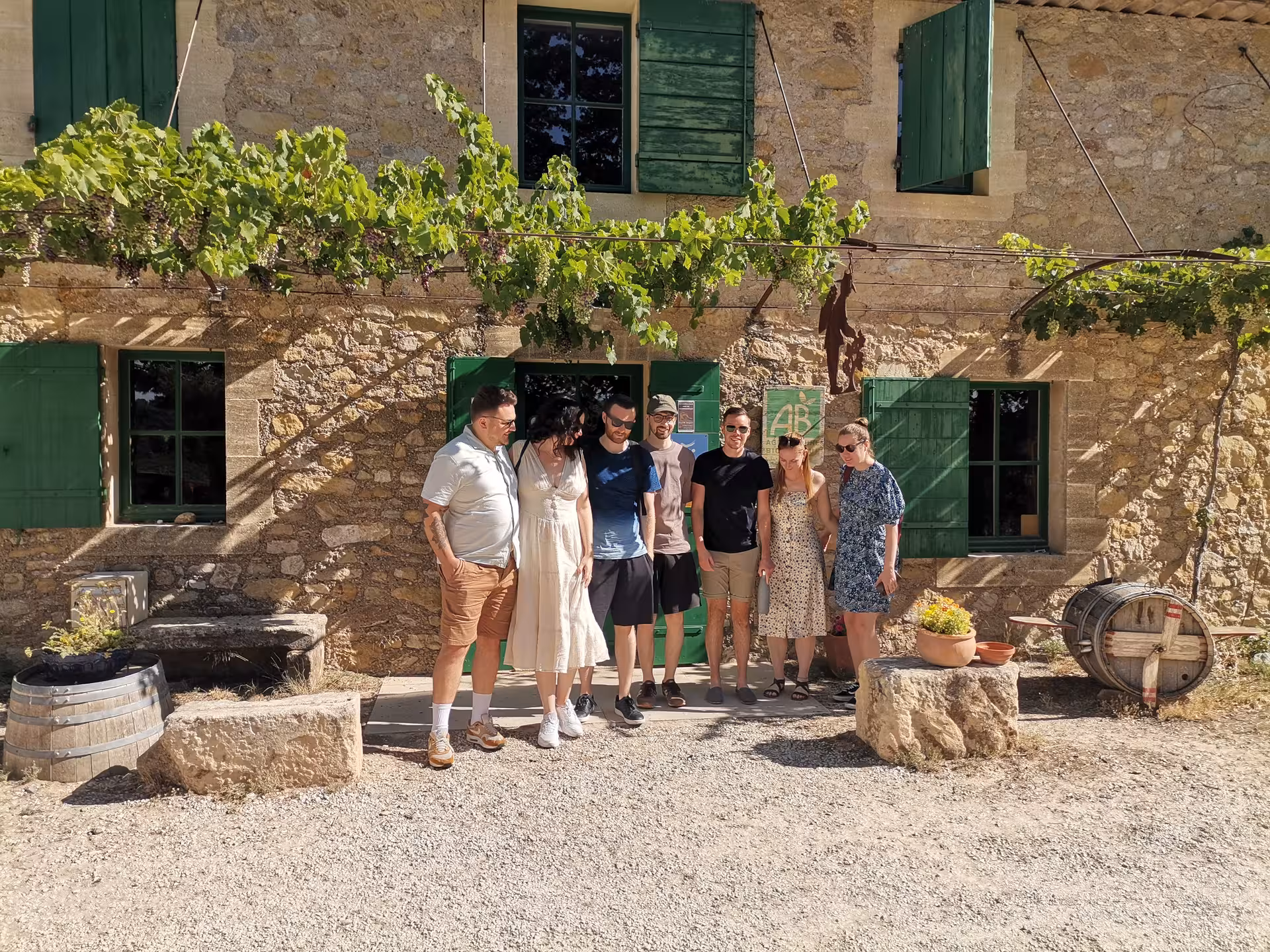 Small group at a rustic Provençal winery with vine-covered façade, Arles and Les Baux lifestyle tour
