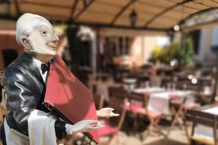 Charming Provence bistro waiter statue, a taste of Luberon village charm on a South of France food and wine tour