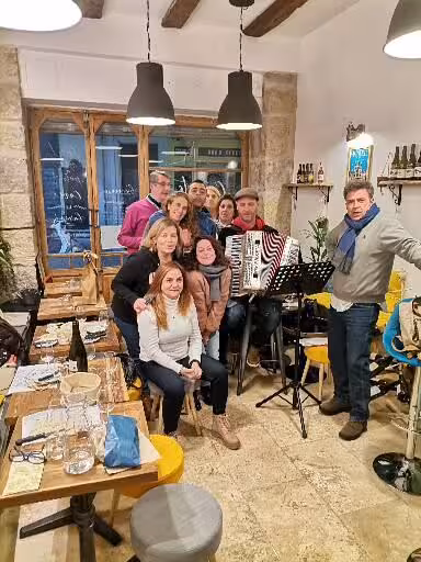 Group enjoying live music in a Provence bistro, cultural evening on 7-day Christian heritage tour