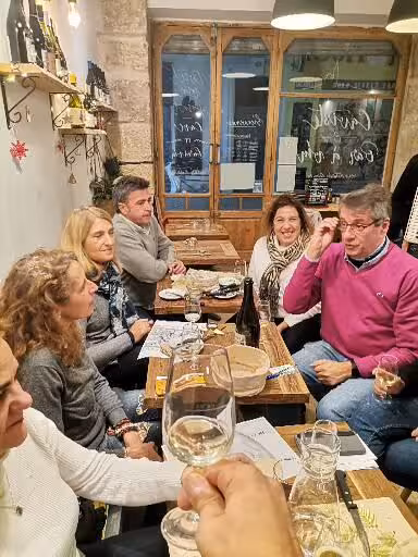 Travelers enjoying Provençal wine tasting at a local bistro, part of a 7-day Christian heritage tour in Provence