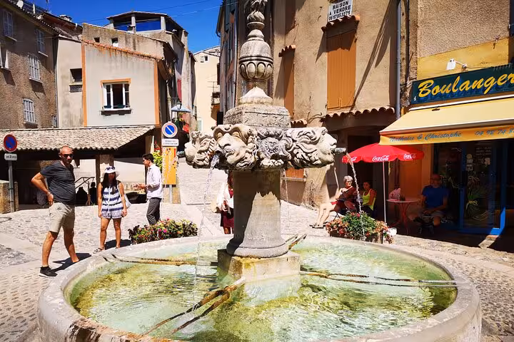 Stone fountain in a charming Provence town square near bakery, included on private full-day lavender fields tour