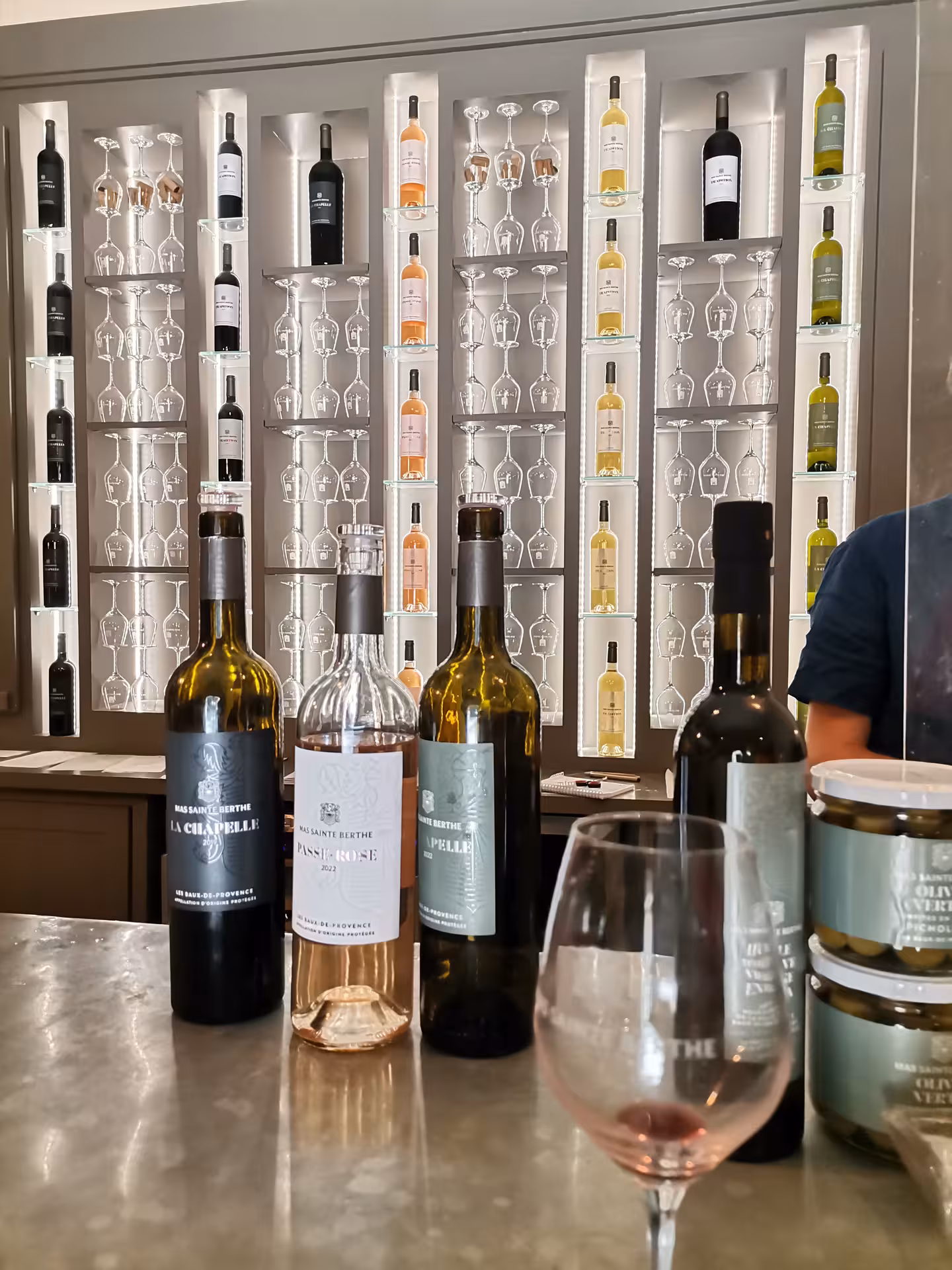 Provence wine tasting bottles and rosé glass at Les Baux-de-Provence cellar, perfect add-on to Arles day tour