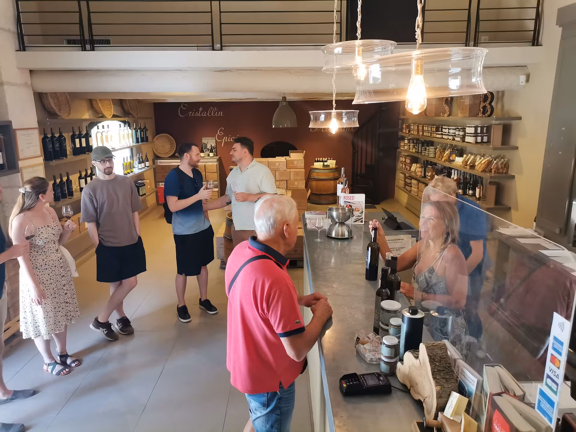 Wine tasting stop in Provence boutique near Les Baux-de-Provence, guests sampling local rosé and olives