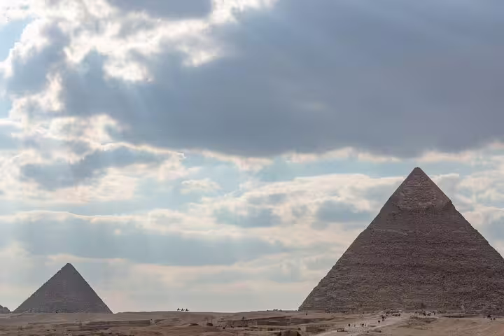 Panoramic view of the Pyramids of Giza under dramatic clouds on Cairo excursion from Alexandria cruise port